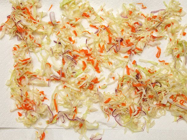 切碎的腌卷心菜、洋葱和胡萝卜撒在纸巾上晾干。