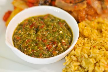 Small bowl of Puerto Rican sofrito next to rice on a plate.