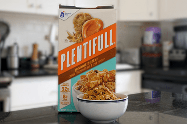 Box of General Mills Plentifull Cereal on a counter with a bowl filled with the cereal in the foreground