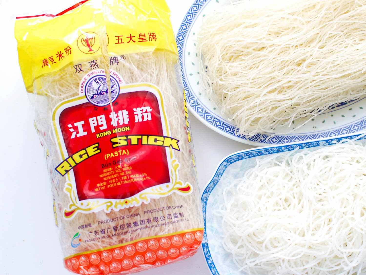 A package of Kong Moon Rice Stick noodles next to plates of uncooked and cooked noodles.