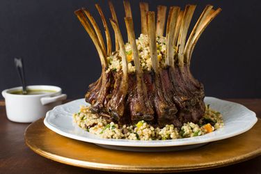 A roasted rack of lamb topped with couscous stuffing.