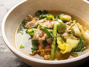 a close up of Gaeng Om Gai (Isan-Style Herbal Curry with Chicken and Dill) in a bowl