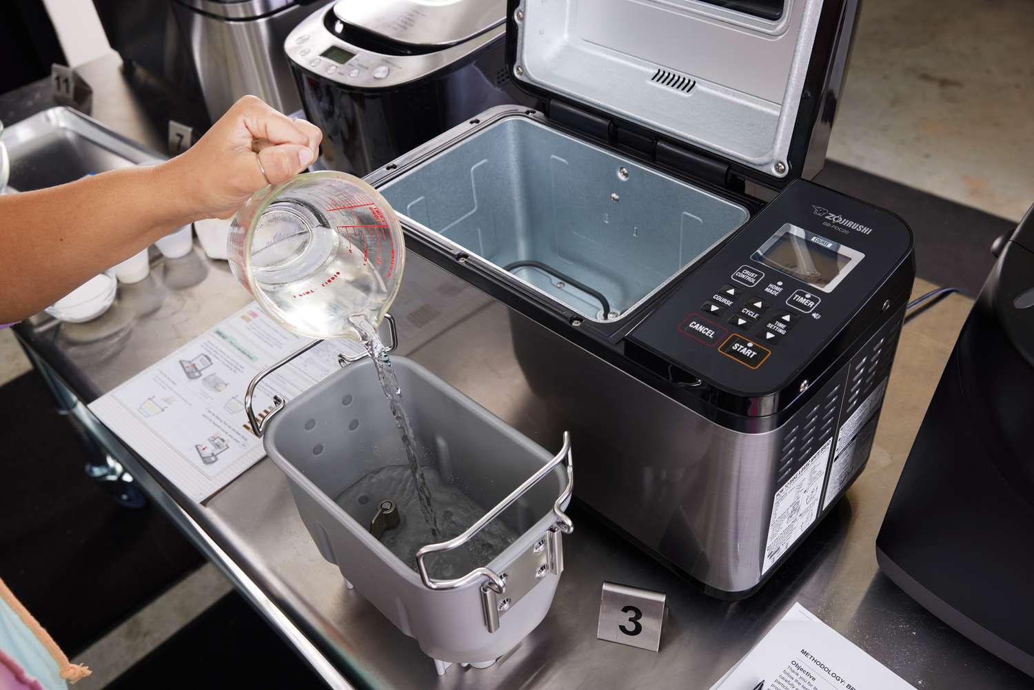 a person adding water into a bread maker's pan