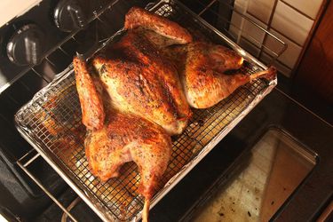 香草擦脆皮蝴蝶烤火鸡放在烤炉的架子上。