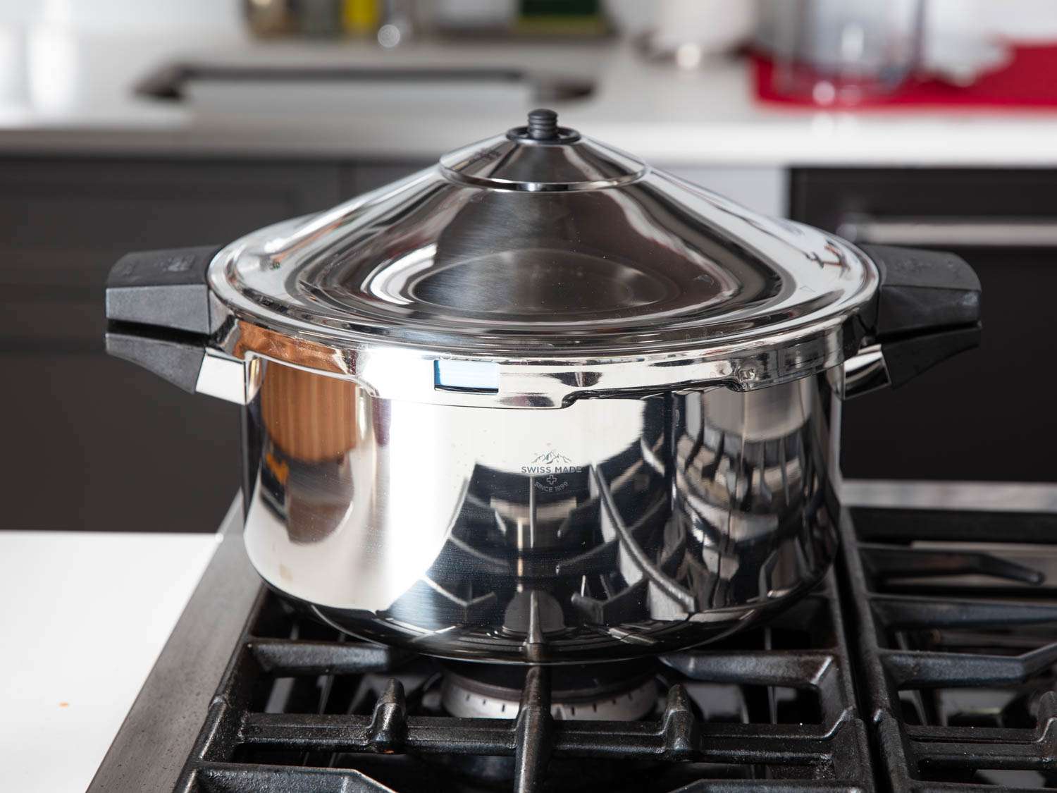 A manual pressure cooker on a stovetop.