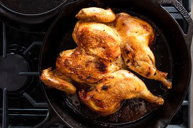一只在炉子上的铸铁煎锅里的全鸡
