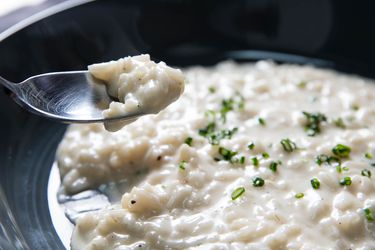 A bowl of risotto sprinkled with chopped chives.