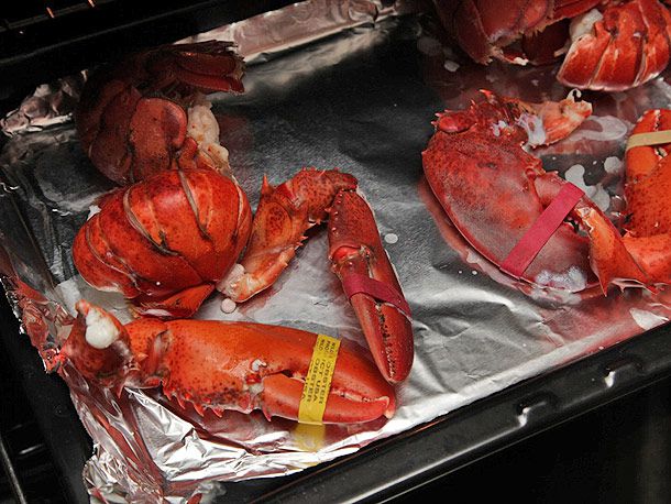 把蒸熟的龙虾放在衬箔的烤盘上，放进烤箱。