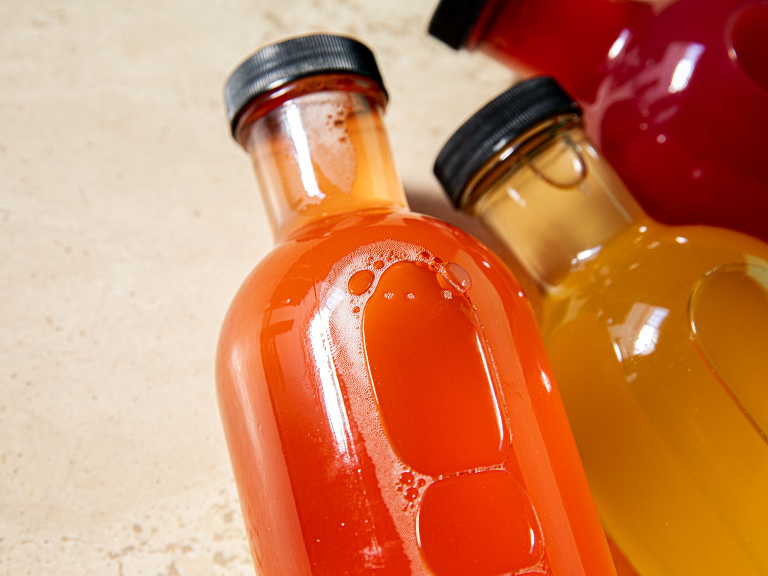 Overhead view of bubbles in three kombucha bottles