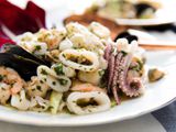 意大利海鲜沙拉与鱿鱼，扇贝，虾和贻贝在一个白色的盘子。