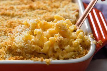 A rectangular casserole dish of macaroni and cheese with breadcrumbs on top.