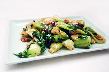 Shanghai baby bok choy with black bean sauce on a square white plate.