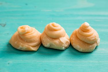 Several pieces of Thai cane sugar. Their shape resembles a miniature swirl of soft-serve ice cream.