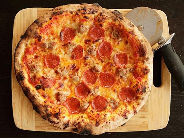 一个披萨店的披萨和一个木板板上的一块。