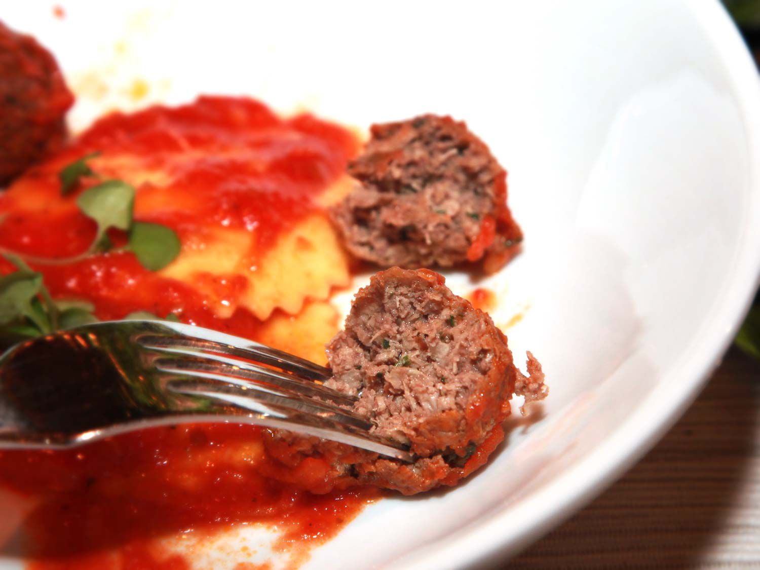 用不可能的汉堡做成的肉丸，配上意大利馄饨和番茄酱。叉子正在夹起一个肉丸子。