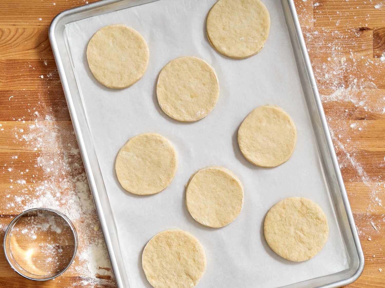 A baking sheet with cut out circles of biscuit dough.