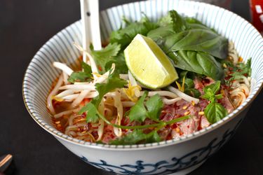 A bowl of Faux Pho, garnished with cilantro, bean sprouts, and a lime wedge.