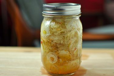 A pint-sized jar of pickled spring onions, fresh out of the water bath and ready for long-term storage.