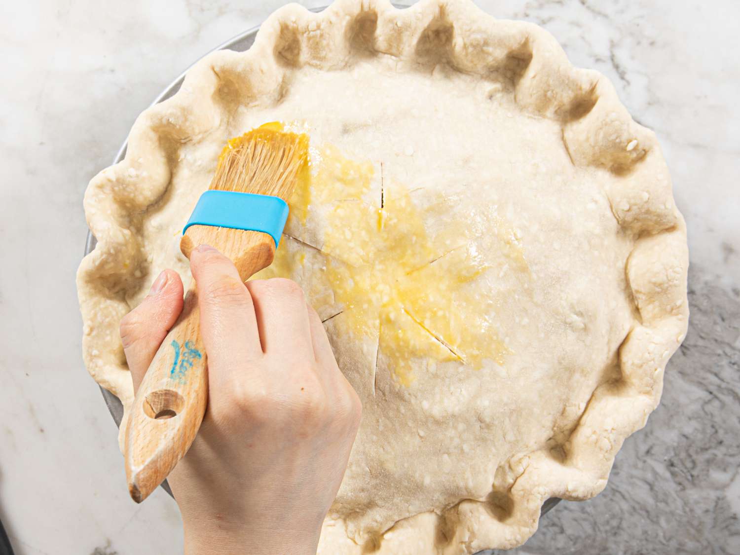 Putting egg wash on pie