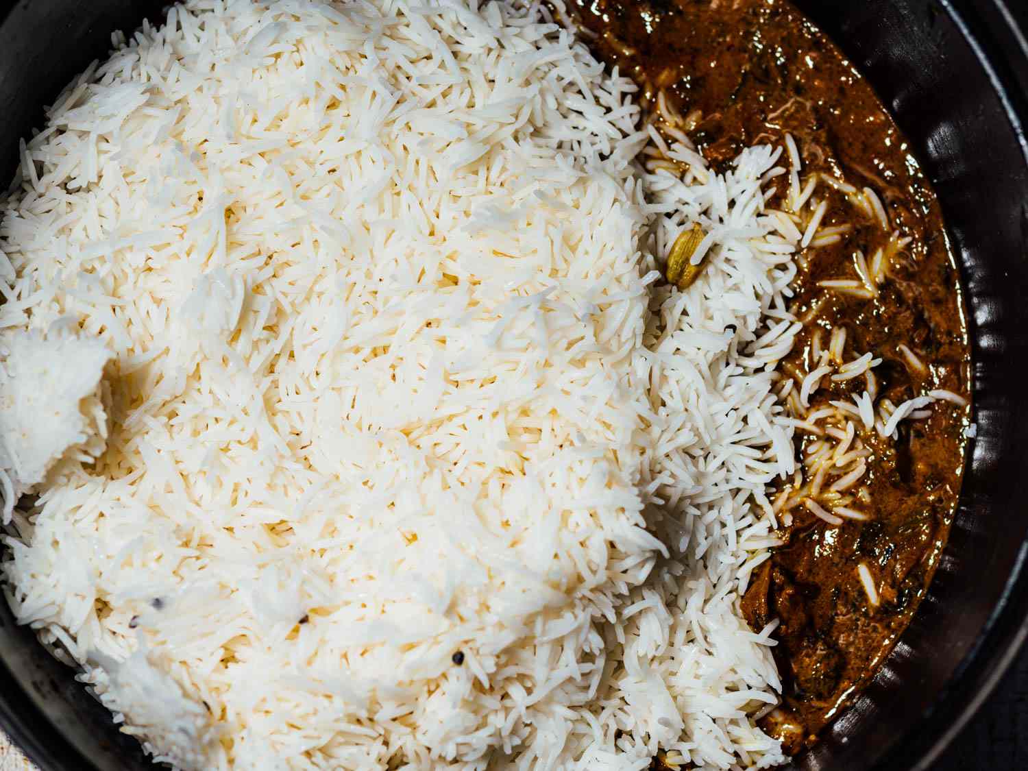 在荷兰烤箱中加入米饭和肉以及印度香饭的腌料gydF4y2Ba