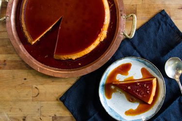 Overhead view of a double-caramel flan with a slice on a plate