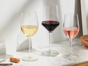 three wine glasses filled with different types of wine