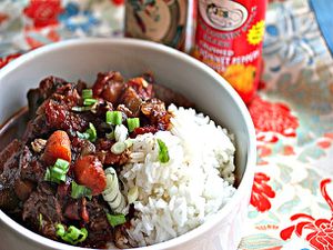 Jamaican Beef Stew in a bowl with white rice and green onions sprinkled on top