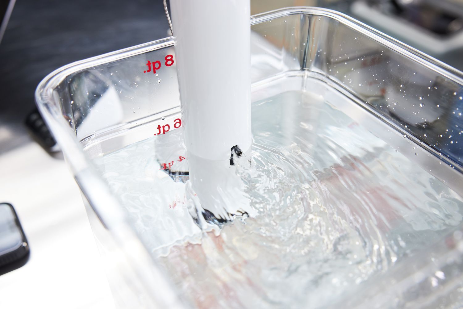 A closeup look at a sous vide machine circulating water in a cambro container
