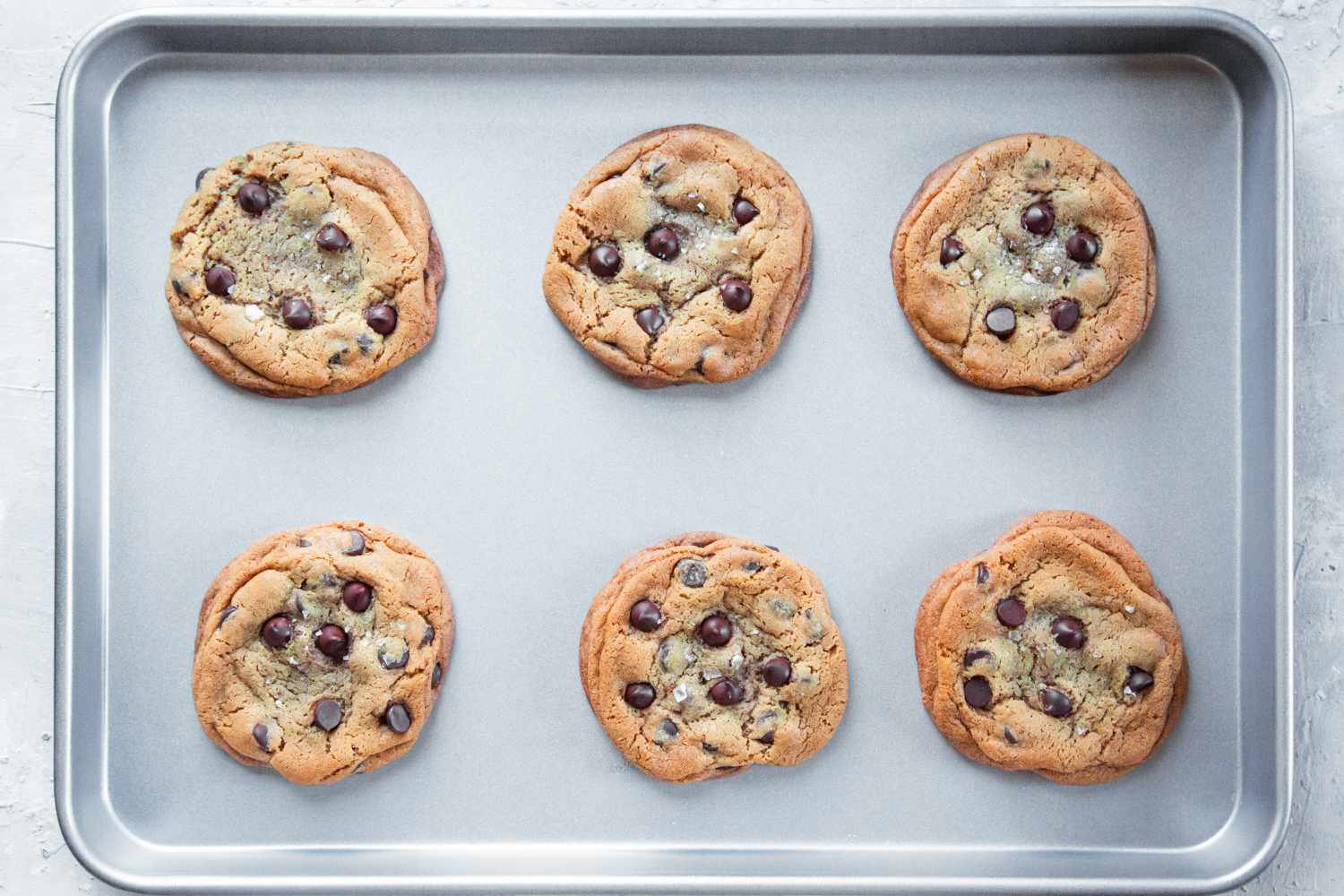 nonstick sheet pan with six chocolate chip cookies on it