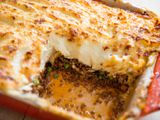 Shepherd's Pie in red casserole dish with one square portion removed