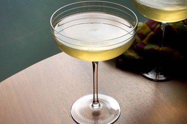 A chamomile tangerine sparkling cocktail in a coupe.