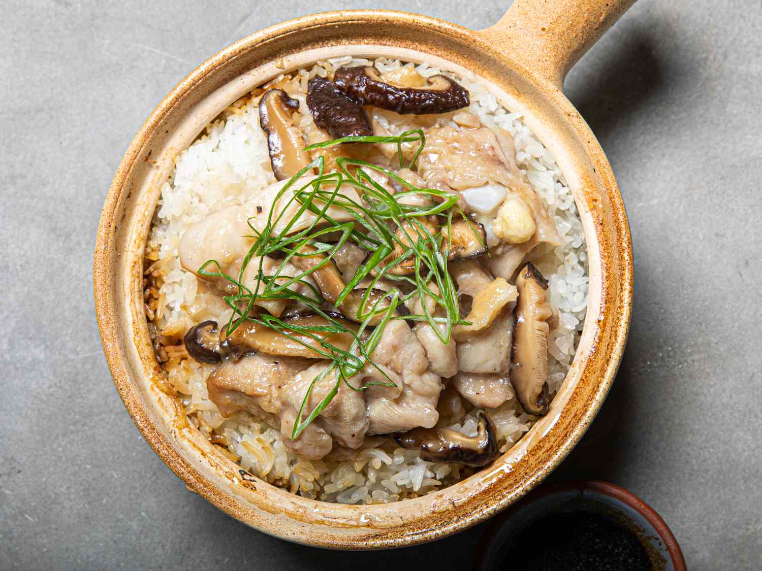 Velveted chicken with mushrooms on top of Cantonese clay pot rice.