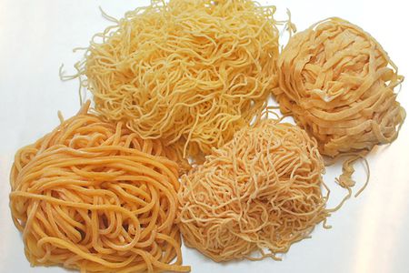 Four piles of different styles of egg noodles