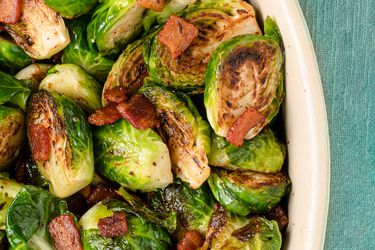 Roasted Brussels sprouts and bacon inside of a ceramic dish.