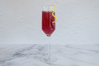 Pomegranate rouge cocktail garnished with a lemon twist.