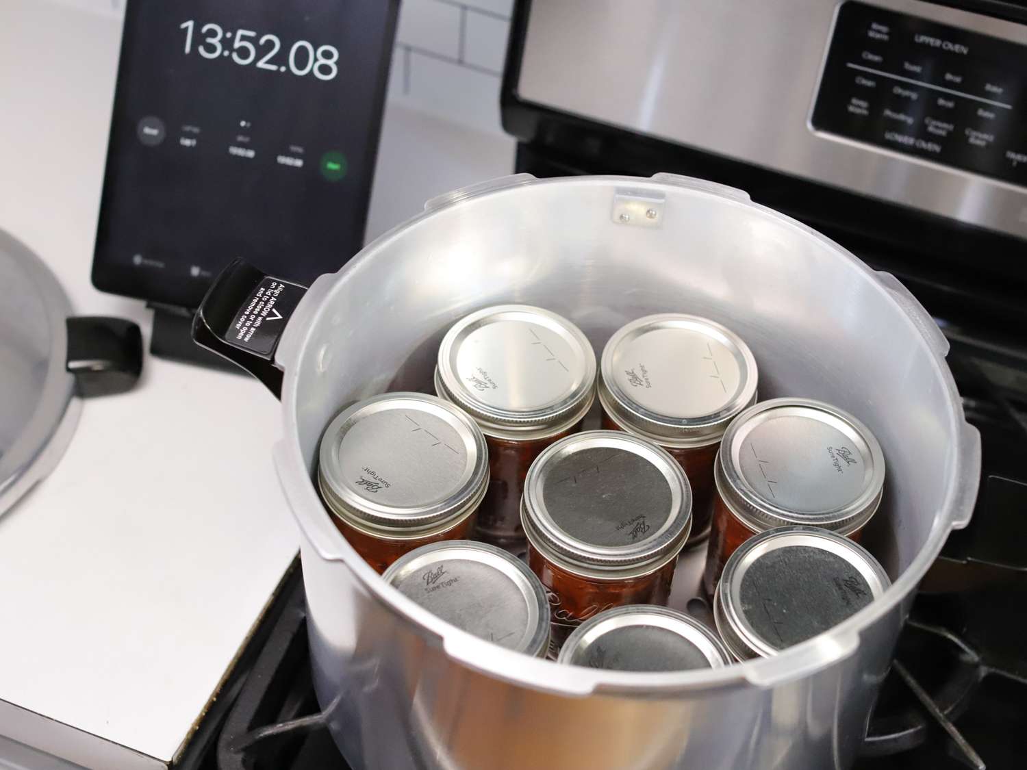 jars of tomato sauce in a pressure canner on the stovetop