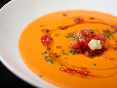 安达卢西亚西班牙凉菜汤的特写，点缀着橄榄油，一些番茄丁和黄瓜丁，韭菜和少量番茄种子。