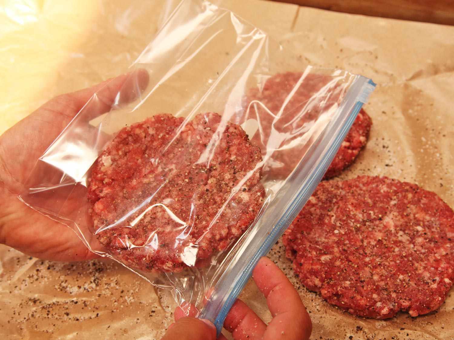 将一个汉堡肉饼放在一个小拉链锁袋，然后通过置换方法密封和真空烹饪。gydF4y2Ba