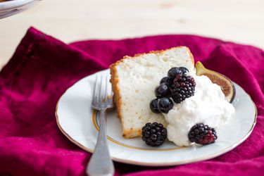 天使蛋糕切片，涂上鲜奶油、新鲜无花果、蓝莓和黑莓gydF4y2Ba