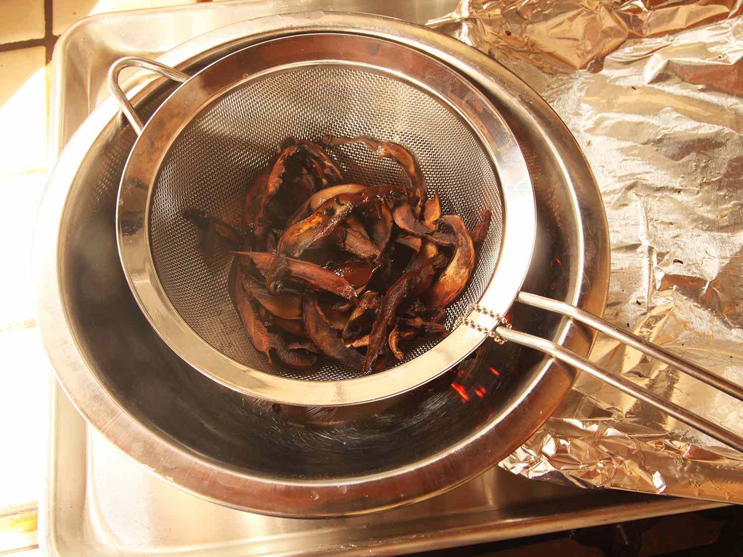 用细网眼滤网将蘑菇切片放入搅拌碗中，与冒烟的木片一起搅拌。