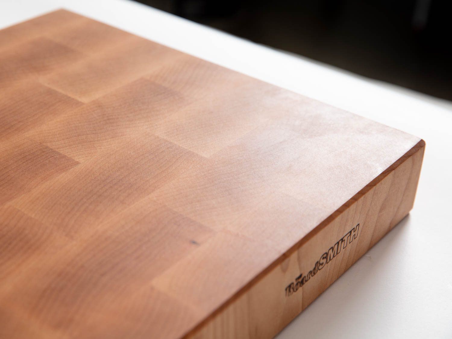 The fine finish on the BoardSmith's end-grain maple cutting board, showing light reflecting off the smoothly finished surface