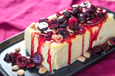 A loaf of honey semifreddo, topped with macerated cherries and Marcona almonds.