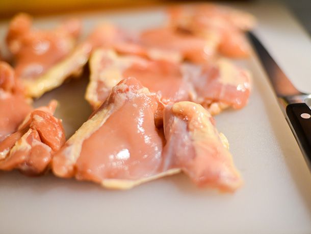 Raw chicken thighs on a cutting board.