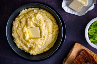 A bowl of homemade grits topped with a square of butter