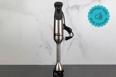 a Vitamix Immersion blender standing upright against a marble backdrop