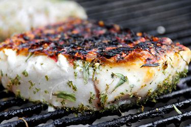 海鲜在烤架上烤的用香草调味的鱼片。