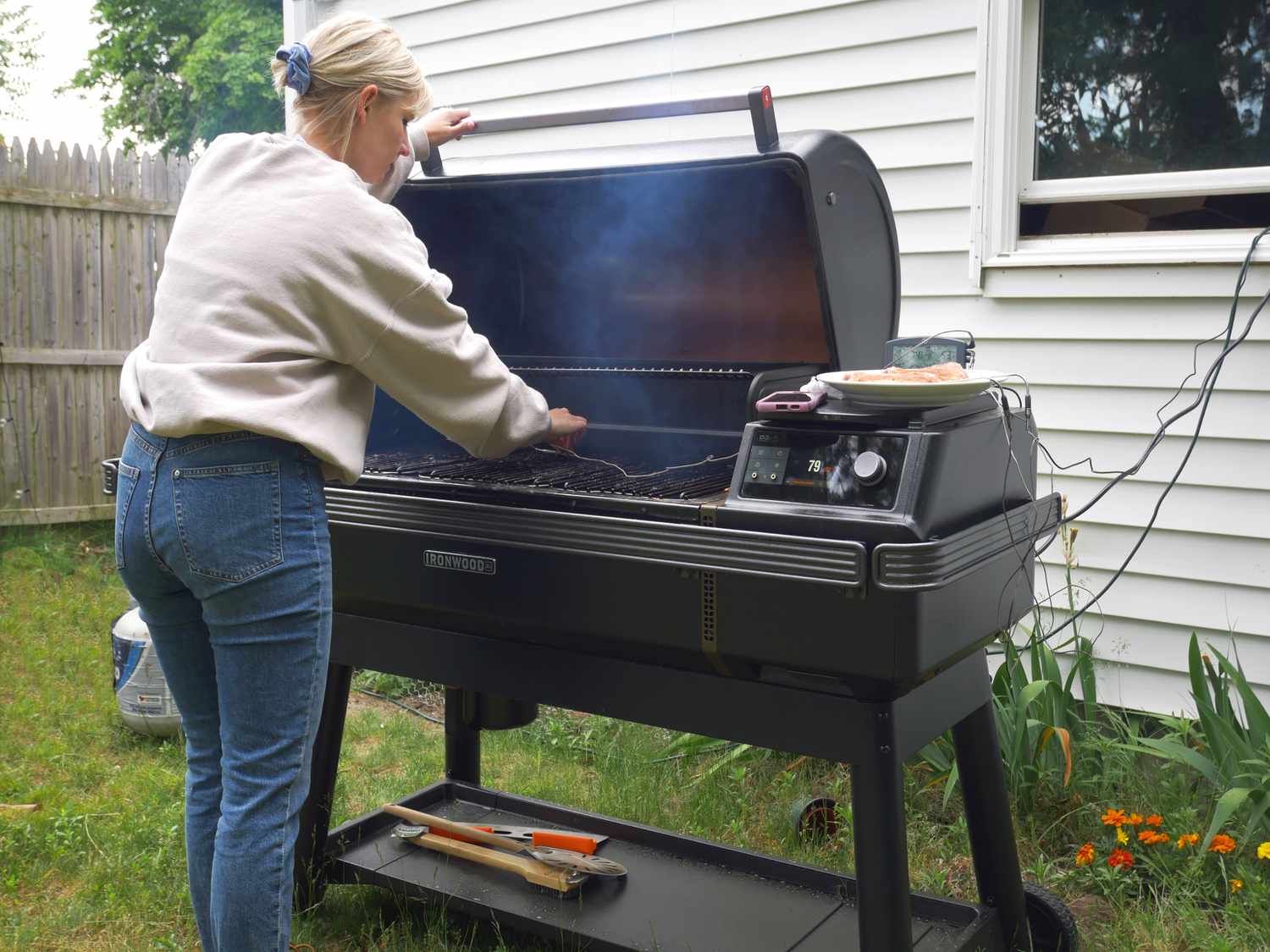 a person placing ambient probe in the center of the open Traeger smoker