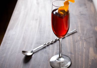 A Negroni Sbagliato cocktail in a fluted glass with a twist of orange peel