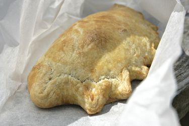 A chicken and leek pastie on parchment paper.