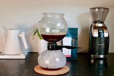 a siphon brewer with its top portion filled with coffee